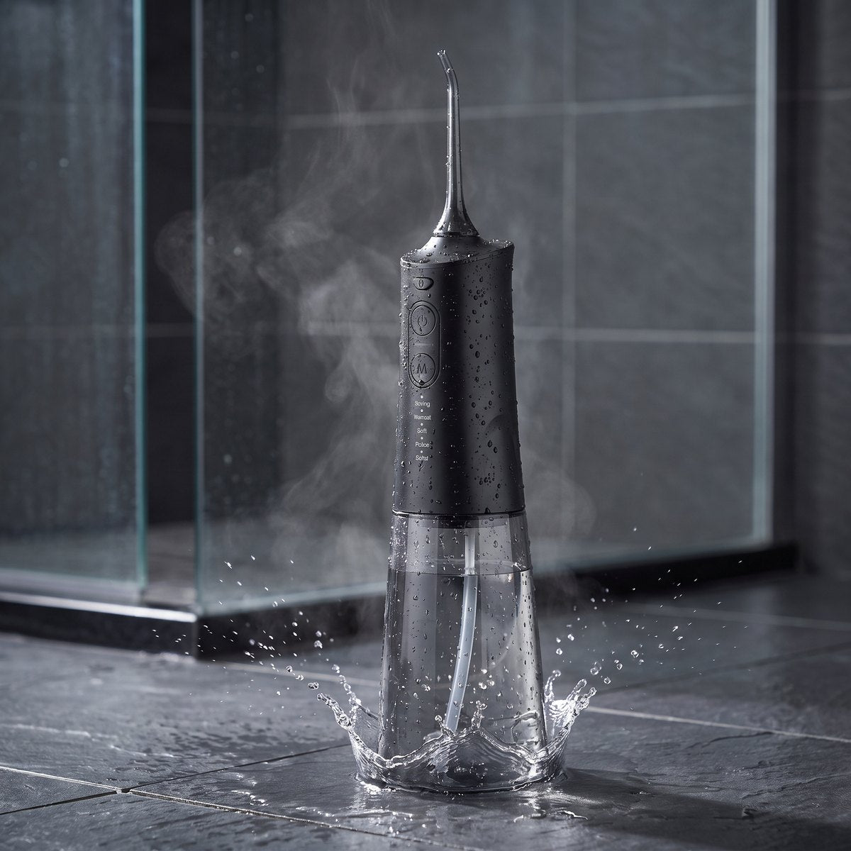 Hydropulseur noir sous la douche, couvert de gouttes d’eau